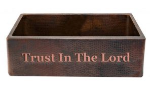 copper kitchen sink with trust in the lord saying on front apron